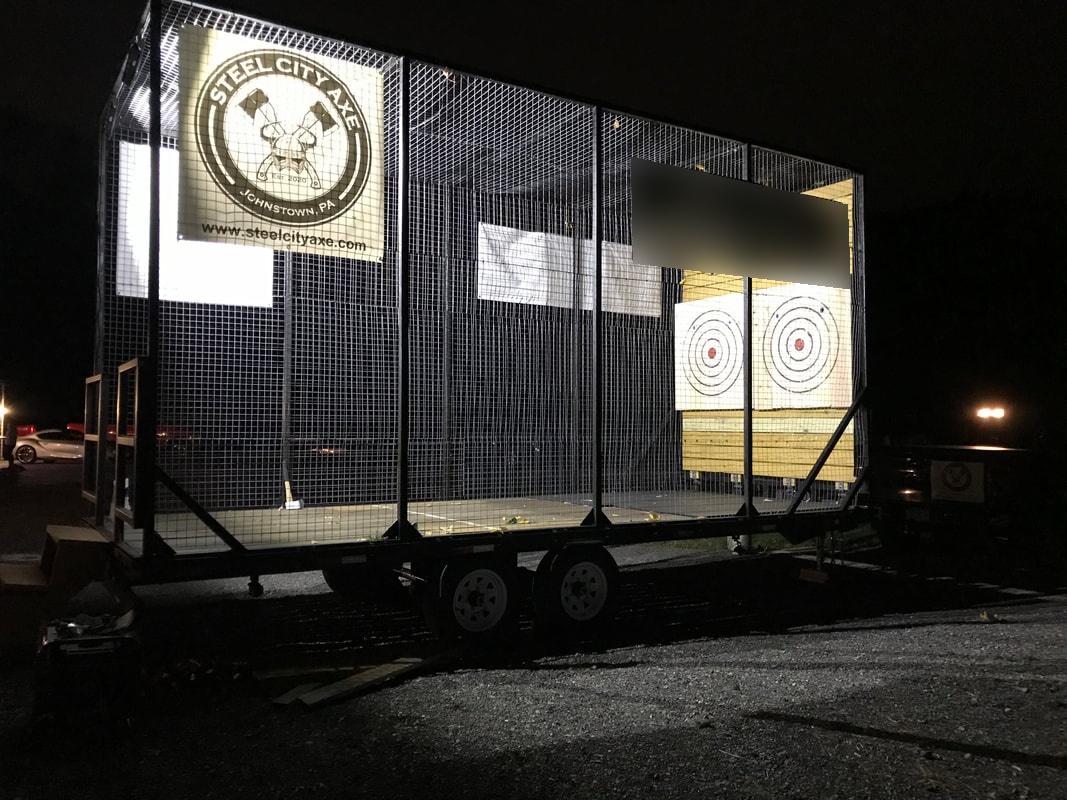 The Steel City Axe axe throwing trailer lit up for an evening event